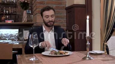 高级餐厅的客人。一个坐在套房里的可敬的男人在欣赏这道肉菜。